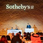 There is a group of people in front of a man on a podium.