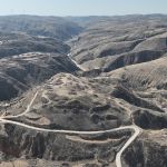Aerial view of brown mountains with road winding through