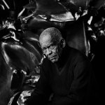 Black and white portrait of Richard Hunter, showing a large sculpture behind him.