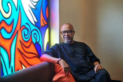 Portrait of Victor Echihameno next to a stained glass window.