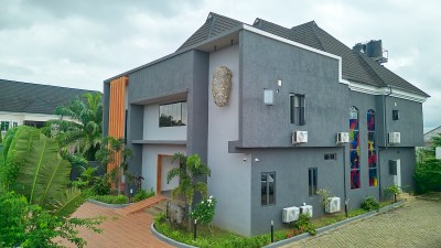A gray blocky building with trees in front.