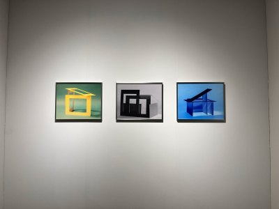 Three highly saturated photographs hang on the wall.