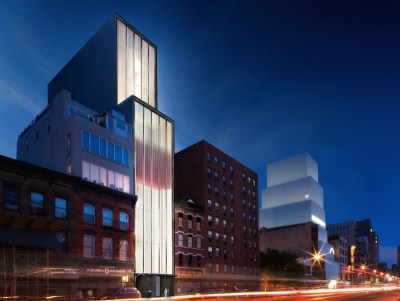 A towering gallery building borders the street, and out-of-focus cars whiz by.