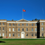 The building under the blue sky, with a lawn in front.