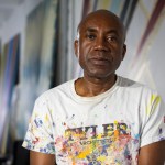 A man wearing a paint-splattered T-shirt