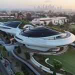 Aerial view of a space-like building with the downtown Los Angeles skyline in the background.