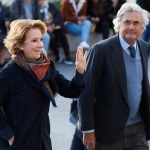 A woman named Esperanza Aguirre and her husband Fernando Ramirez de Haro arrived for the funeral. She waved, wearing a dark coat and colorful scarf. He had gray hair and was wearing a suit jacket and tie.