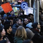 Protesters hold signs during demonstrations on the streets of New York City.