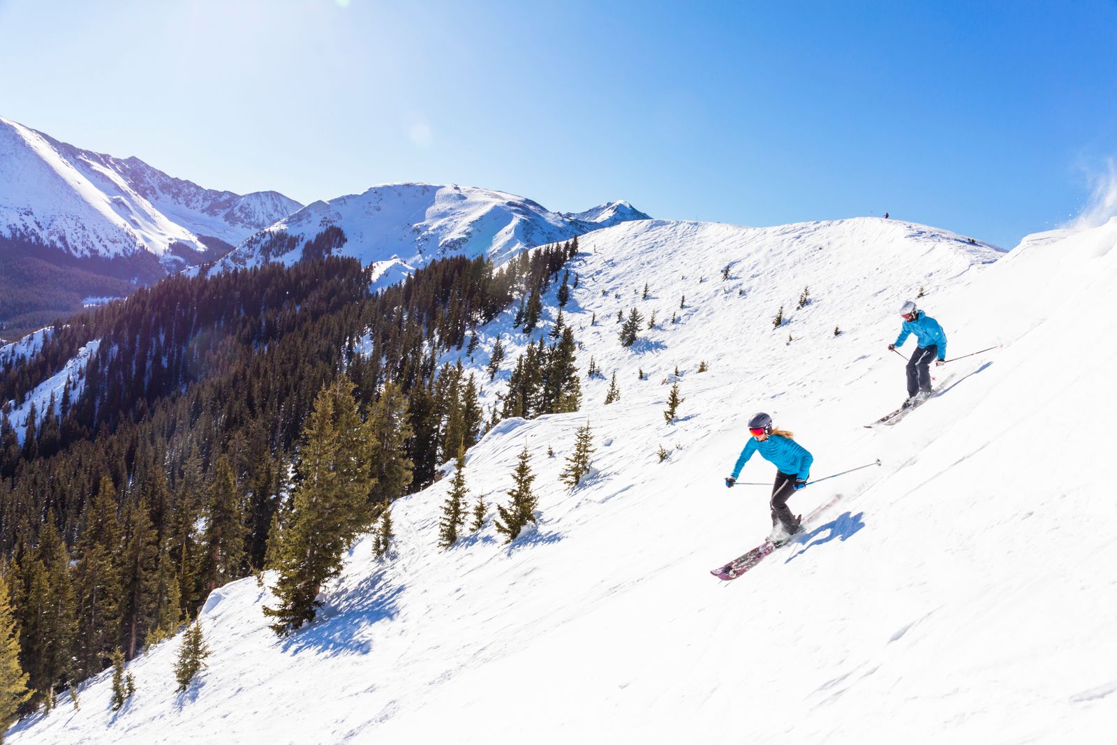 Couple skiing on snowy mountain slopes