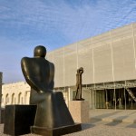 Exterior view of the museum with scaffolding. The sculpture can be seen in the foreground.