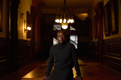Portrait of Sandra Mujinga in a dark room.