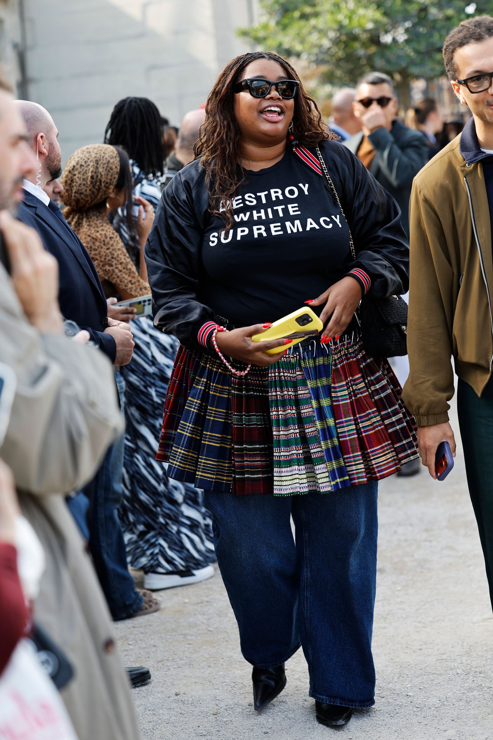 Image may contain clothing, dresses, adults, tartan accessories, bags, handbags, coats, faces and heads