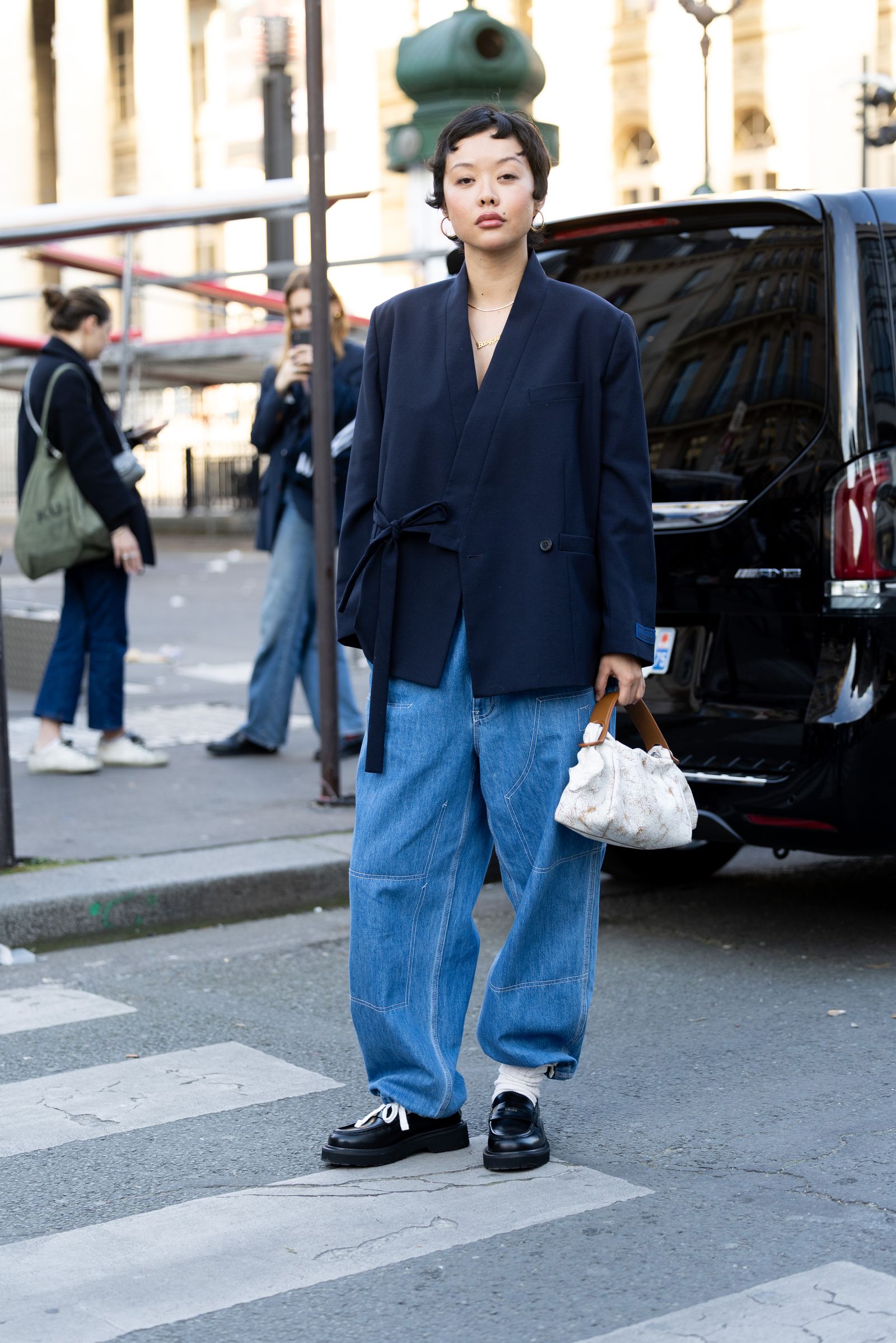 Image may contain clothing, pants, people, accessories, bags, handbags, jeans, adult blazers, coats and jackets