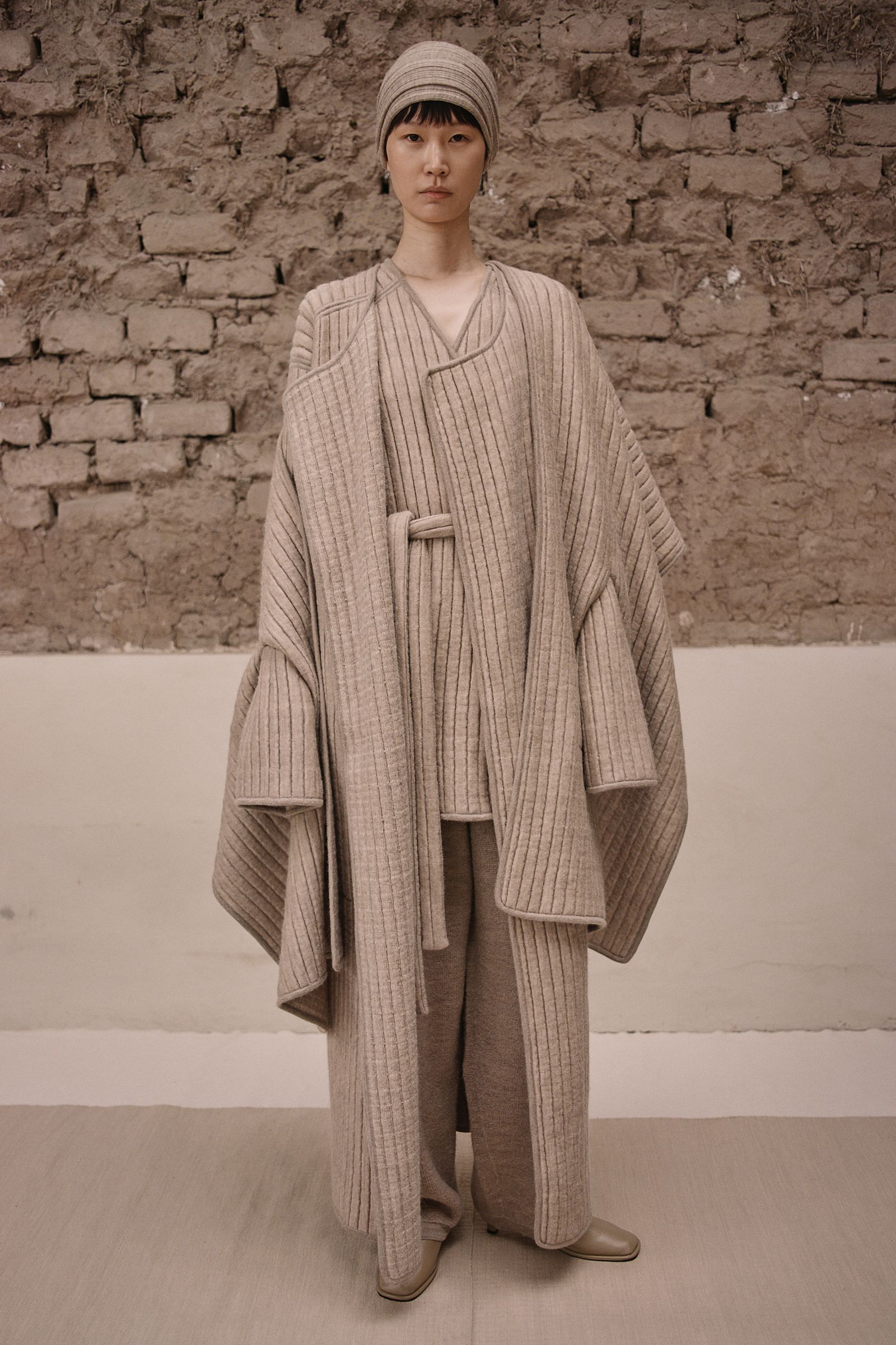 Image may contain fashion clothing, outerwear, adult faces, heads, knitwear and sweaters