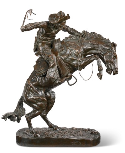 A bronze sculpture shows a cowboy on a rearing horse.