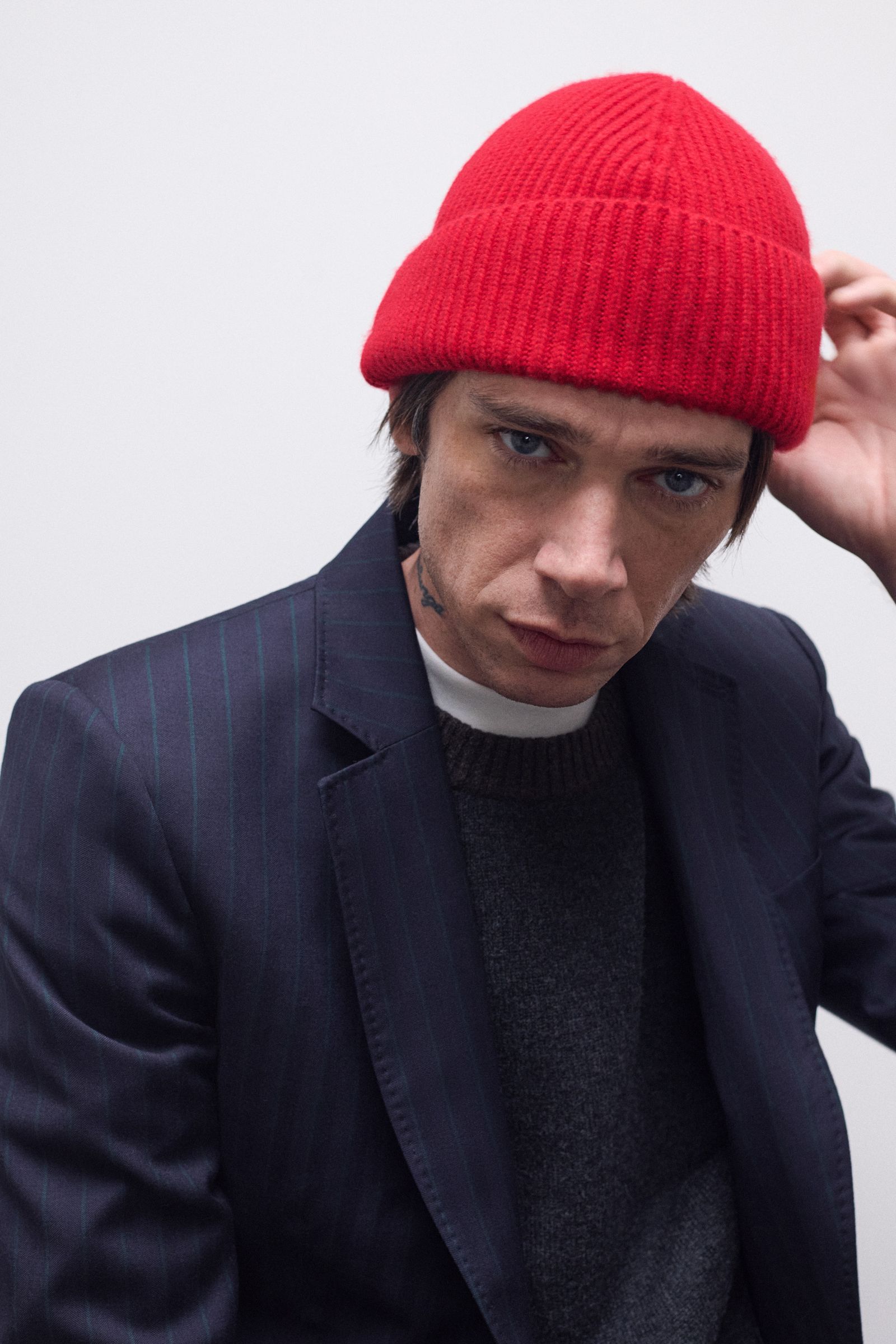 Image may contain hat, costume, hat, adult, coat, beanie, face and head