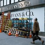 A man walks past a Tiffany & Co. store. The windows were blocked and various ladders were leaning against them.