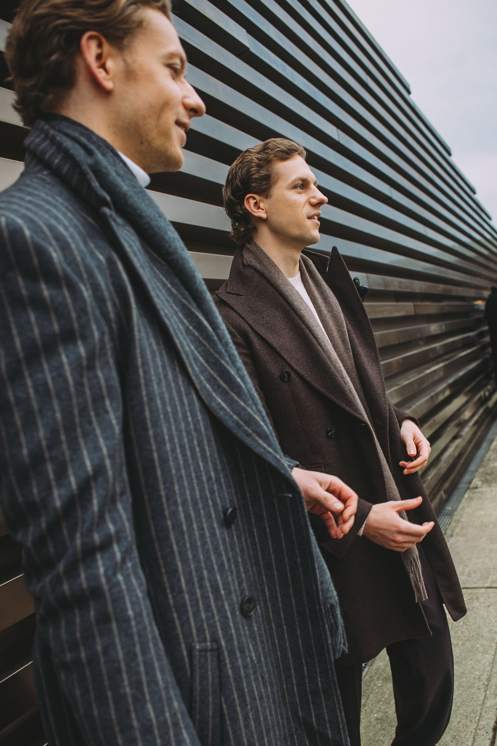 The image may contain clothing, jackets, blazers, formal suits, interlocutors, adult heads and faces