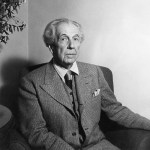 One photo shows 77-year-old American architect Frank Lloyd Wright. He has receding gray hair and wears a three-piece suit and tie.