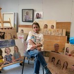 Portrait of Lorena Levi sitting cross-legged in a series of wood paintings.