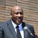 Portrait of Guyton McKenzie speaking into a microphone.