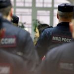 A woman is taken away by the police.