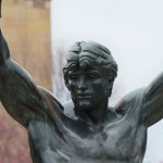 Statue of boxer with hands raised.