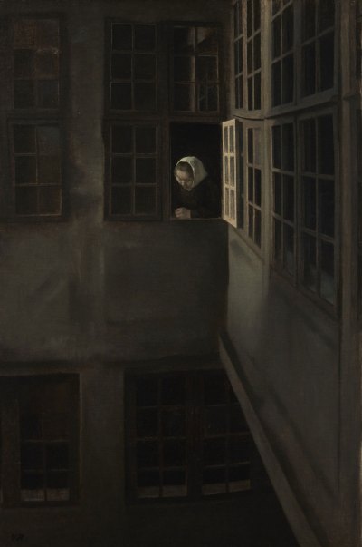 A woman wearing a white headscarf looks out of a building window.