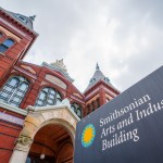 A sign in front of a red brick tower reads 