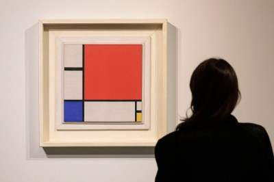 A woman stares at an abstract painting.