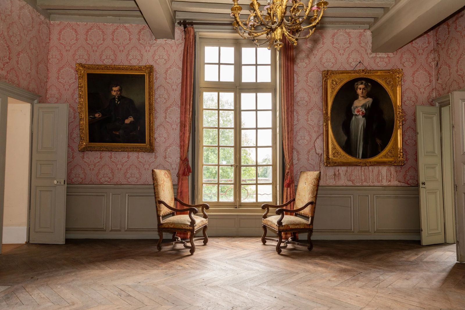 Image may contain french windows, windows, chairs, furniture, adult art paintings, chandeliers and lamps