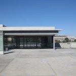 The entrance to an empty-looking building, surrounded by concrete.