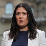 A woman in a white suit.