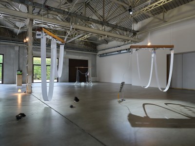 Two long sheets of paper hang from the gallery ceiling.