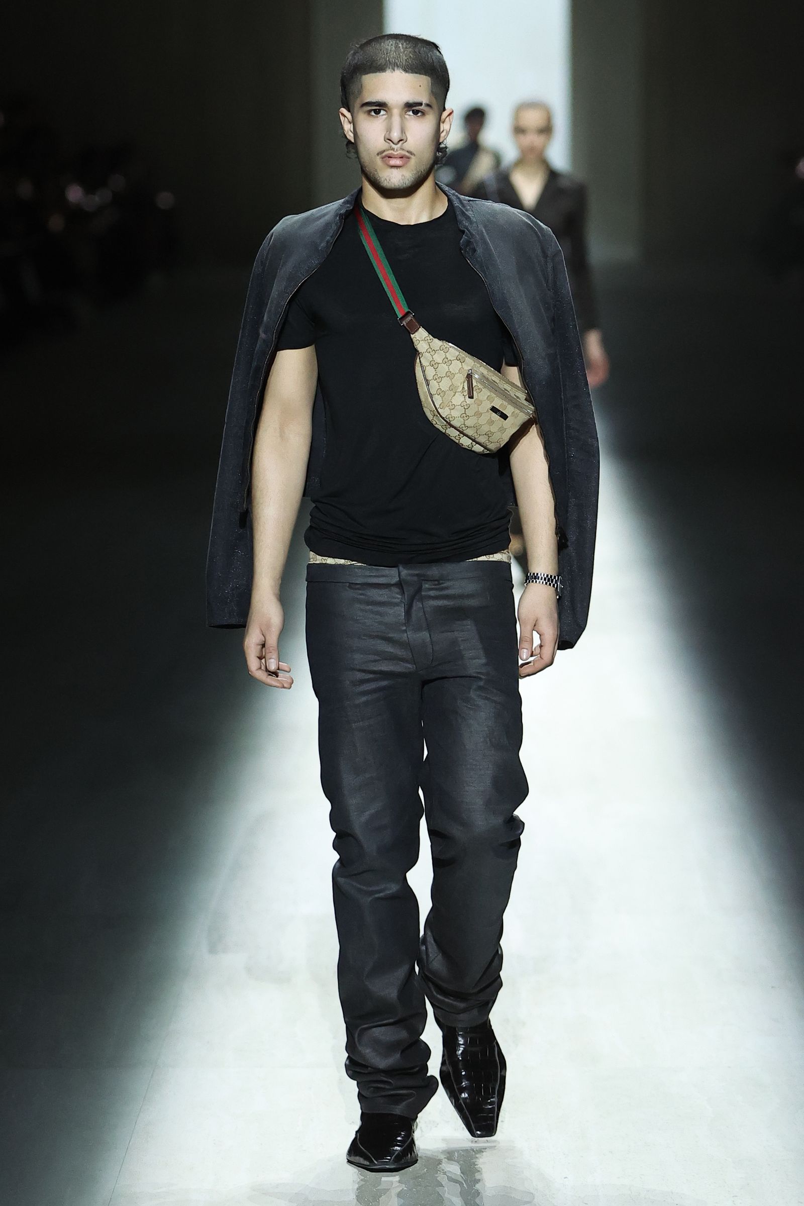 Image may contain clothing, pants, fashion adult standing, long sleeves and jeans