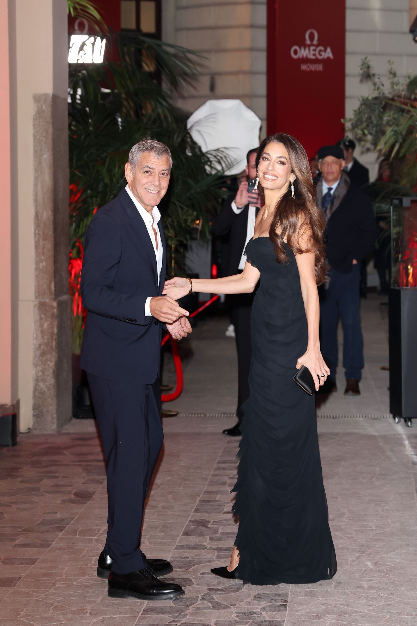 George Clooney and Amal Clooney attend the opening night of Omega House during the 2026 Winter Olympics in Cortina, Milan...