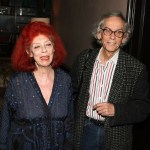 A red-haired woman and a man in a cross-hatched jacket.