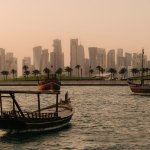 Doha skyline with traditional ships in the port.