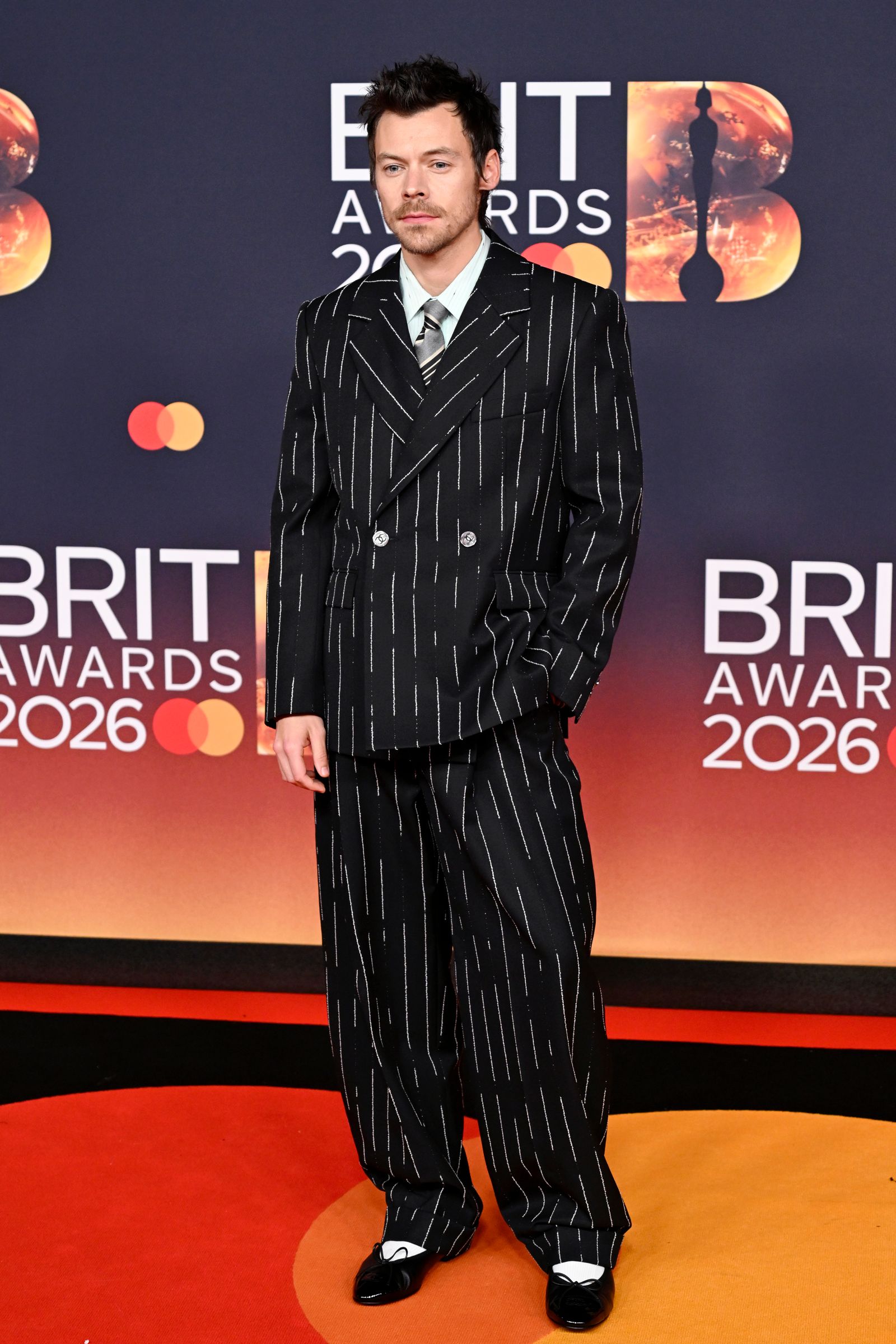 Image may contain Harry Styles clothing formal suits, fashionable adult coats and pajamas