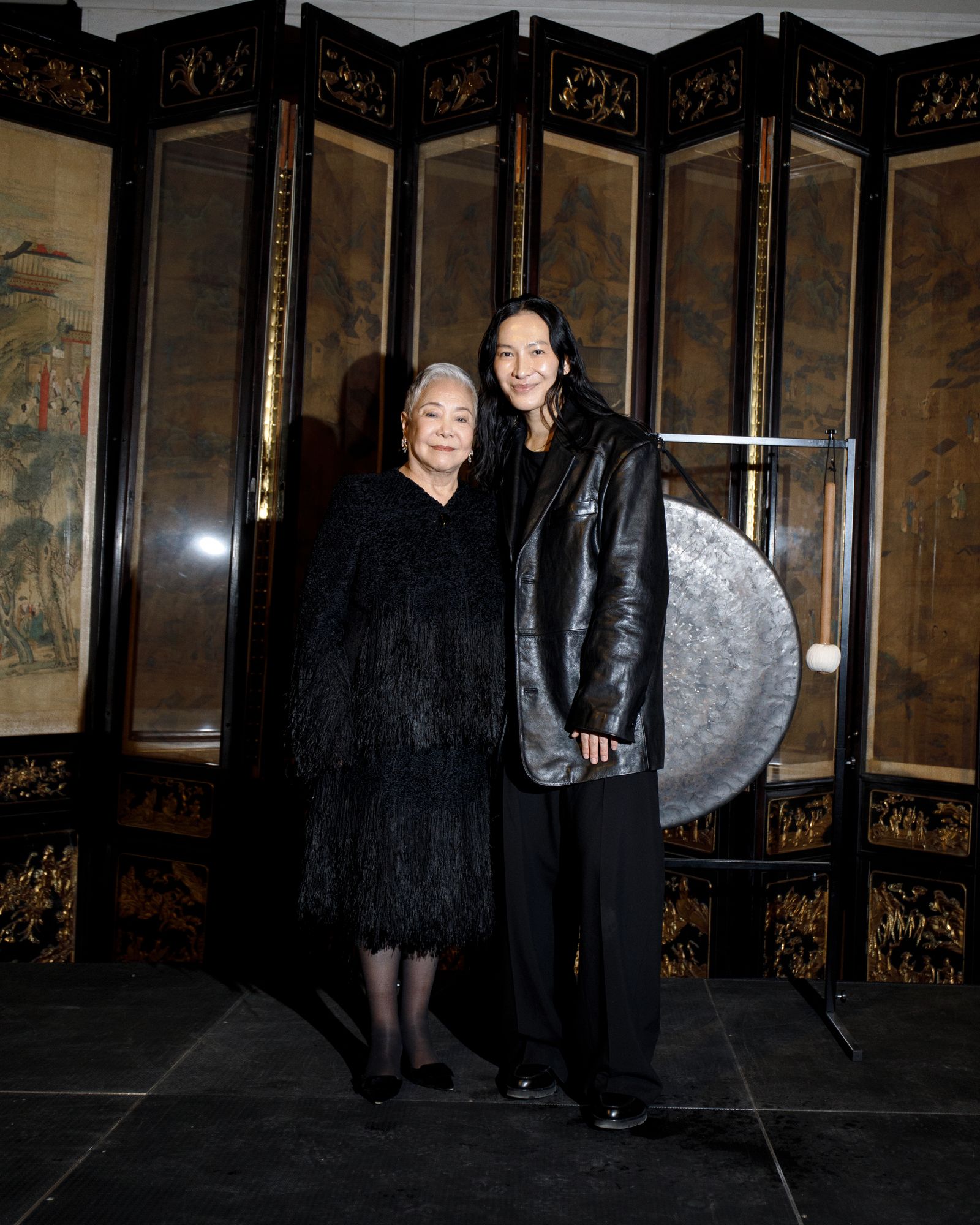 Image may contain Alexander Wang Tian Hua Clothing Coats Jackets Adult Footwear Shoes face and head