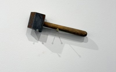 The hammer is attached to the wall with two large screws. 