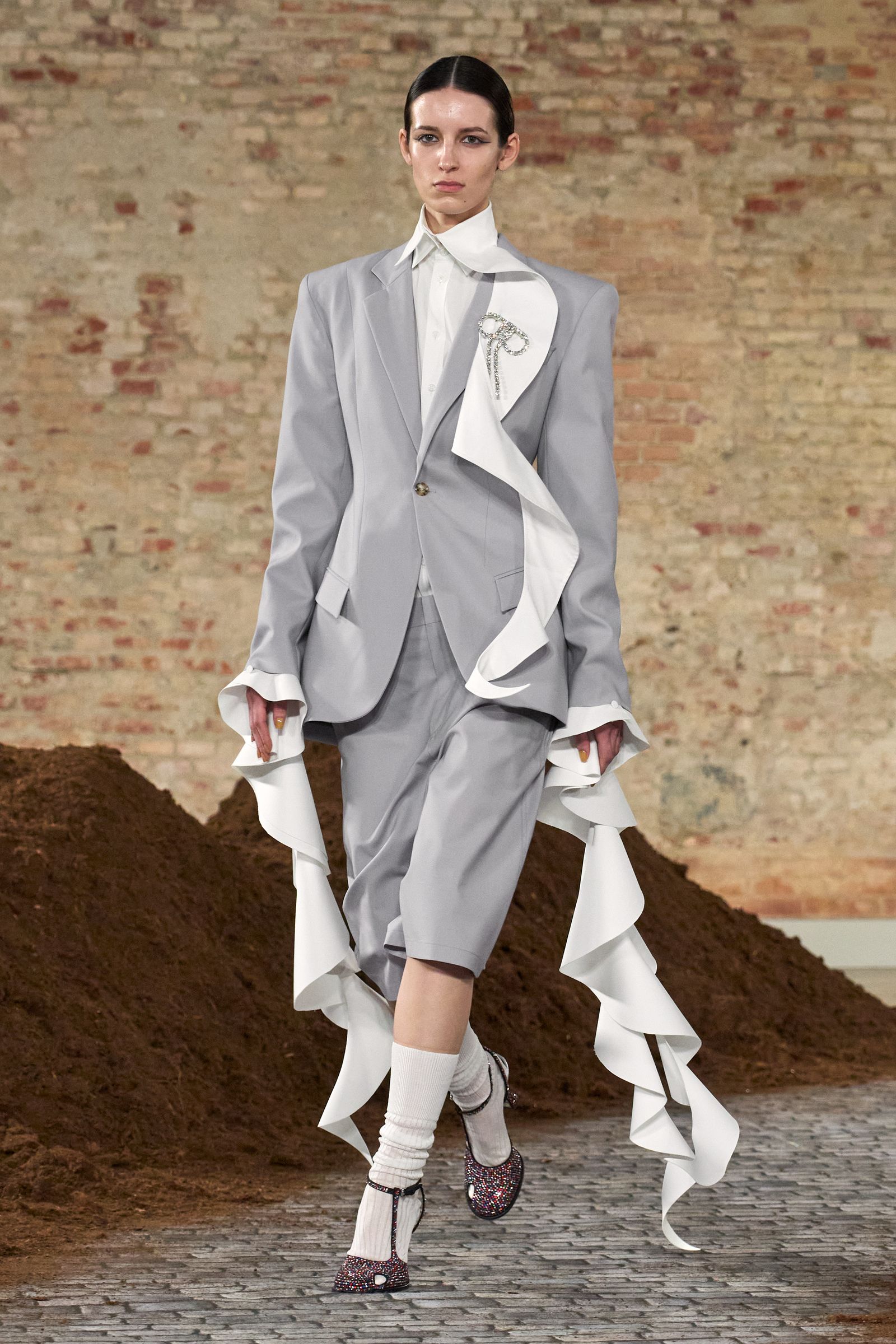 Image may contain clothing: formal suits, blazers, coats, jackets, tuxedos, adult footwear and shoes