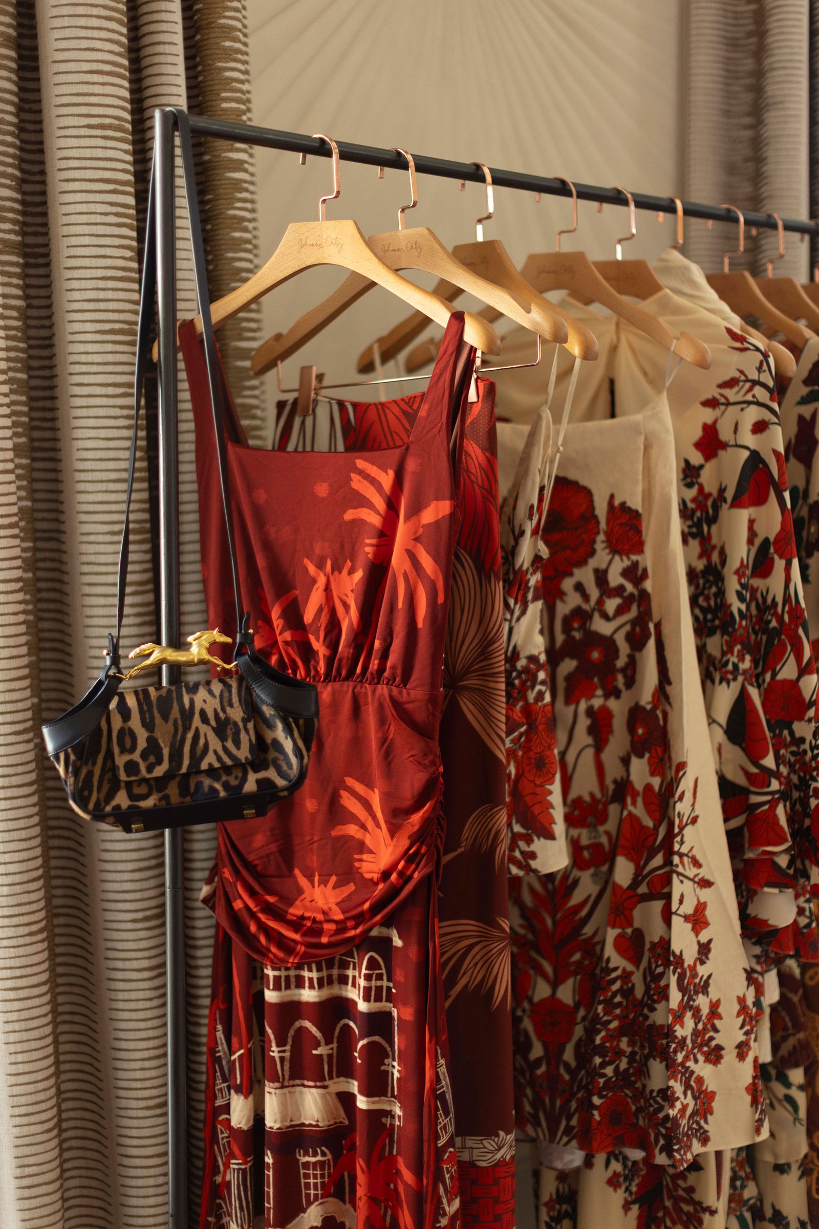 Image may contain dressing room, interior, room accessories, bag, handbag, wallet, boutique, clothing and dresses