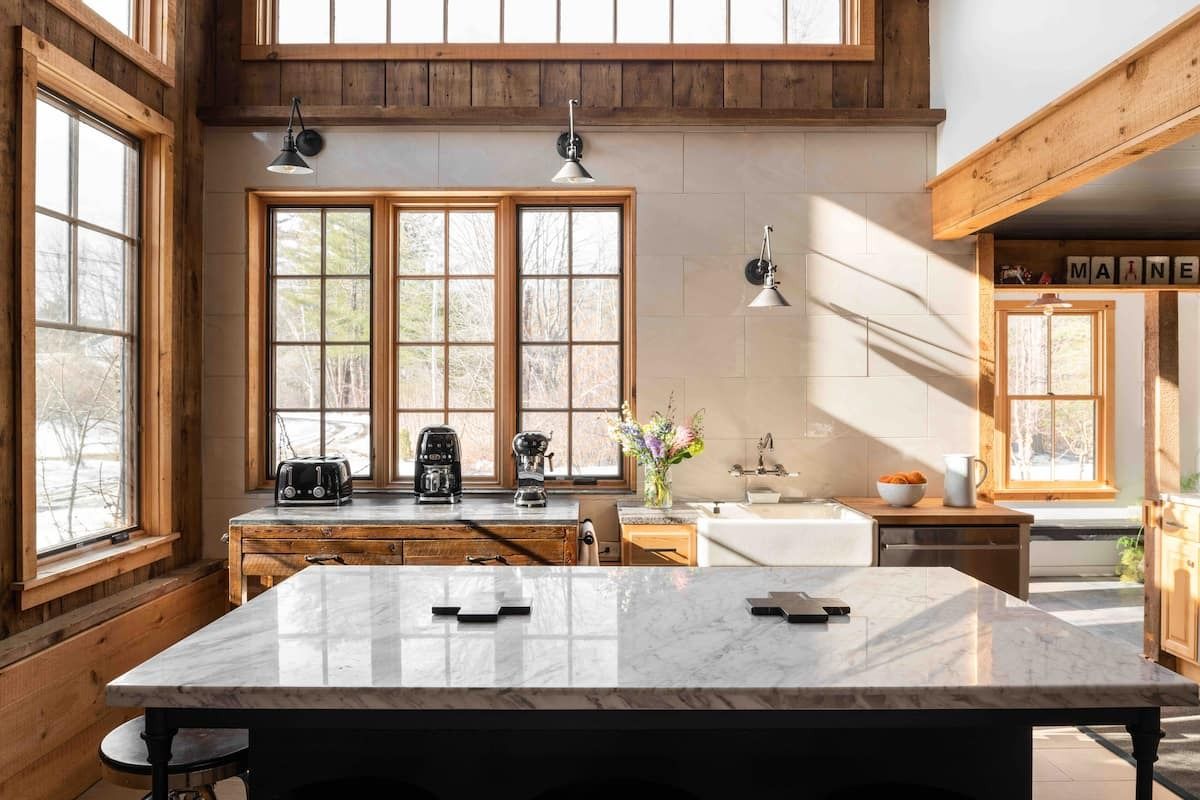 Image may contain interior interior design, light sink, wood, hardwood, stained wood, window, table, furniture and table