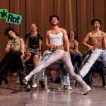 Five dancers stand behind four others, bending over and lifting their buttocks.