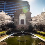A photo shows the neoclassical facade of the Pennsylvania Museum in front of a rectangular pool and courtyard trees blooming in spring