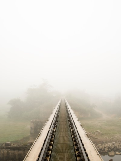 A railroad track leads into the fog.