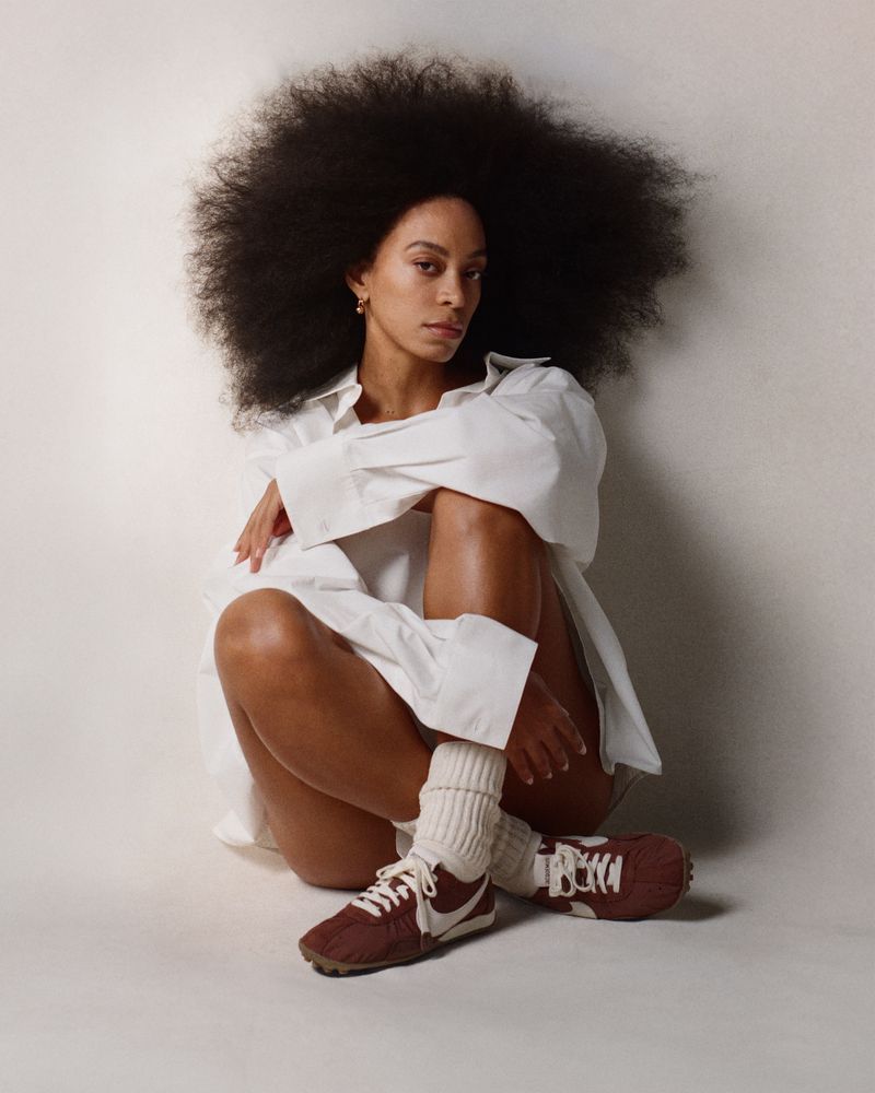 Image may contain Solange person sitting clothing footwear shoes adult face head photography portrait and hair