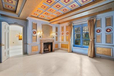 Interior view of upscale apartment with marble fireplace and coffered ceiling. 
