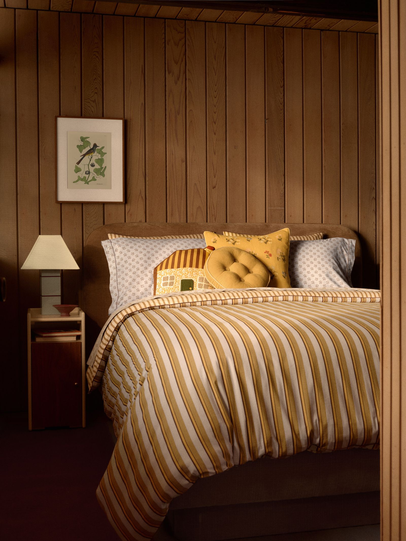 Image may contain interior interior design, cushions, home decor, wooden boards, lamps, bed, furniture, art and paintings